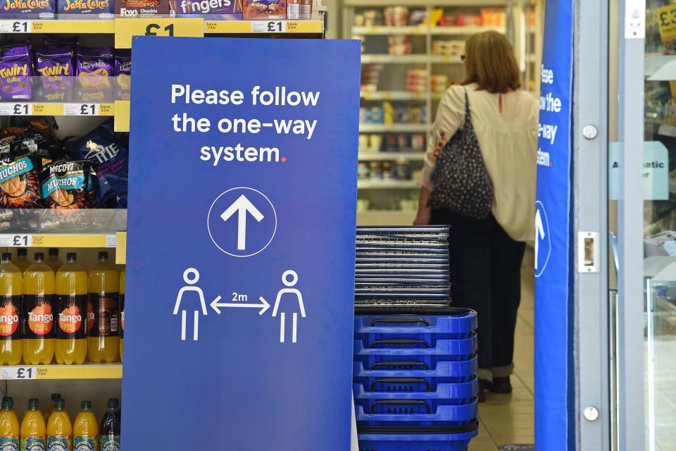 A sign instructing shoppers to maintain social distancing is seen at the entrance to a Tesco supermarket in Lincoln, Eastern England on April 20, 2020, as life in Britain continues during the nationwide lockdown to combat the novel coronavirus pandemic. - The number of people in England who have died in hospital from coronavirus has risen by 429 to 14,929 according to daily health ministry figures on Monday, April 20. (Photo by Oli SCARFF / AFP) (Photo by OLI SCARFF/AFP via Getty Images)