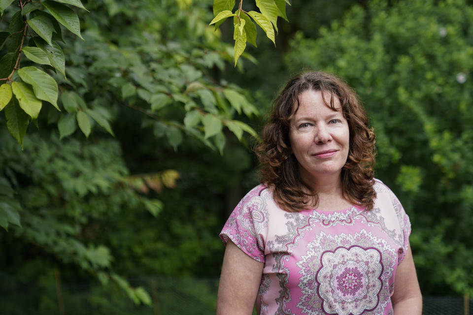 Julie Akey poses for a photograph in her back yard in Herndon, Va., Tuesday, June 22, 2021. What she didn’t know at the time she was at the Fort Ord military base in California was that the ground under her feet, and the water that ran through the sandy soil, was polluted with a cancer-causing class of chemicals including benzene and trichloroethylene. She’d learn this decades later, while trying to understand how, at just 46 and with no family history, she was diagnosed with a terminal blood cancer. (AP Photo/Patrick Semansky)