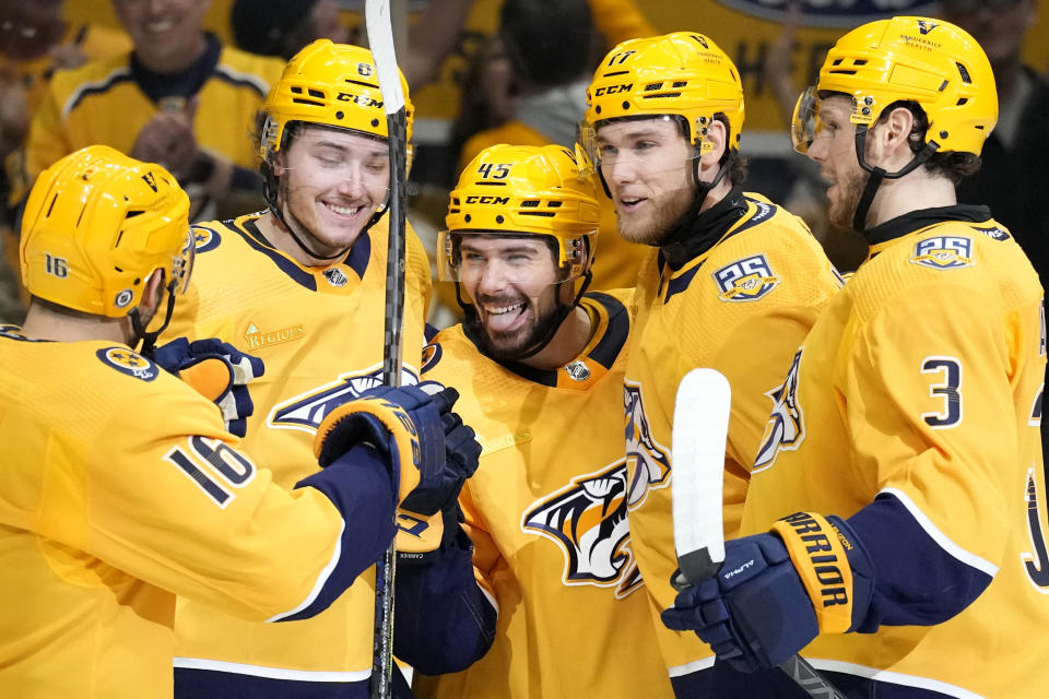 Nashville Predators' Alexandre Carrier (45) celebrates with teammates after scoring against the Columbus Blue Jackets during the second period of an NHL hockey game Saturday, April 13, 2024, in Nashville, Tenn. (AP Photo/Mark Humphrey)