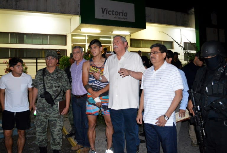 Mexico's Governor Egidio Torre Cantu (c) speaks to members of the press following the release of the Mexico football star Alan Pulido (4-l) on May 30, 2016 in Tamaulipas, Mexico