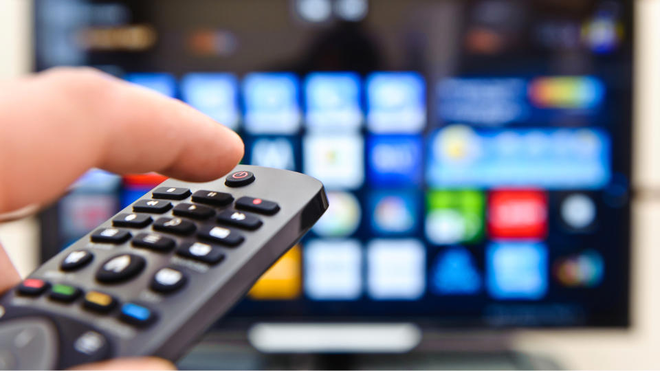 Image of someone using a remote controller operating a smart TV