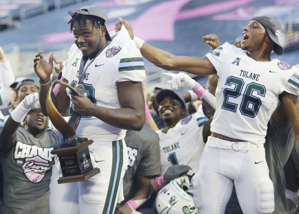 Tulane players Darius Bradwell (10) and Thakarius Keyes (26) celebrate after winning the Cure Bowl NCAA college football game against Louisiana in Orlando, Fla, on Saturday, Dec. 15, 2018. (Stephen M. Dowell/Orlando Sentinel via AP)