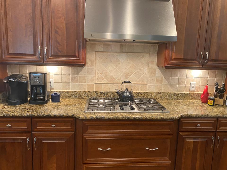 BEFORE: Tan tumbled marble tiles accompany this tired, 20-year-old kitchen.