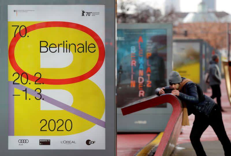 A pedestrian walks past an advertising billboard for the upcoming 70th Berlinale International Film Festival in Berlin