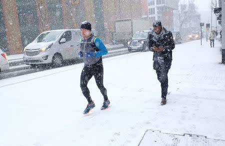 A man jogs during a snow shower in London, Britain, February 27, 2018. REUTERS/Hannah McKay