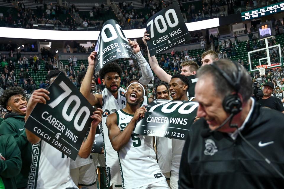 Michigan State's head coach Tom Izzo, right, gives a post game interview as players celebrate his 700th win after the Spartans beat Michigan on Tuesday, Jan. 30, 2024, at the Breslin Center in East Lansing.