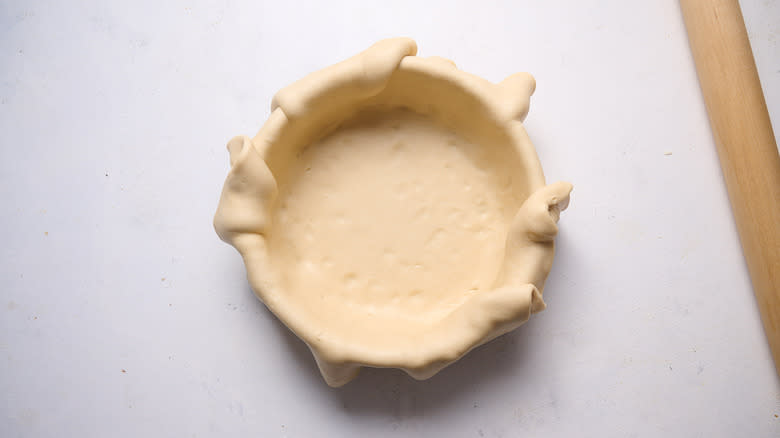 pressing dough into pie pan
