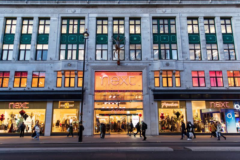 FILE PHOTO: People walk past a store of clothing retailer Next in London