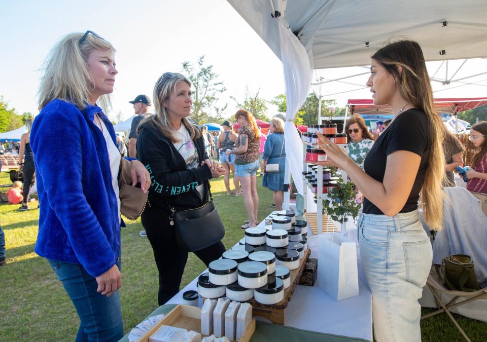 From right, Alex Saenz, of Misha Skincare, talks about her products with Chrissie Calarco and Kristie Calarco during the opening day of The Market of Milton at Jernigan’s Landing in downtown Milton on Thursday, March 30, 2023.