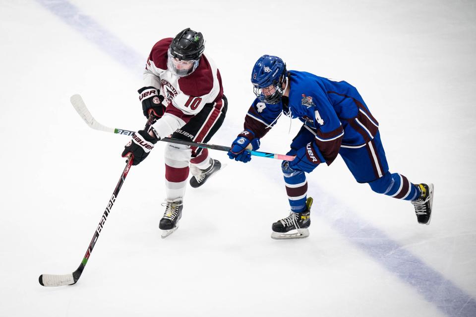 Fitchburg's Cole Howard keeps the puck from Lunenburg's Logan Martin.