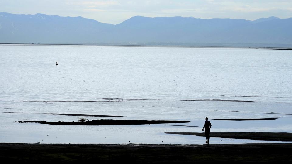 A man looks over the Great Salt Lake on June 7, 2023, in Magna, Utah. Workers, hobbyists and residents who rely on the Great Salt Lake are rejoicing this year after winter's snow melted and led to a 6-foot rise at the lake. (AP Photo/Rick Bowmer)