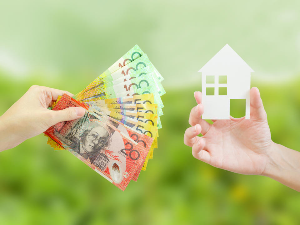 Client giving Australian money to property agent for buying house. 