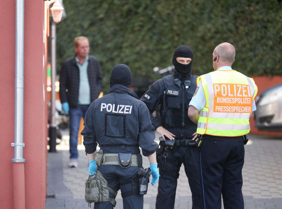 Bundespolizisten samt Pressesprecher vor einem der durchsuchten Objekte (Bild: dpa)