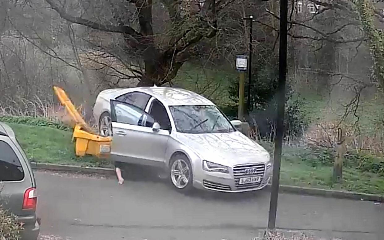 CCTV footage shows the moment the driver of an automatic car falls out of his vehicle as it reverses at high speed