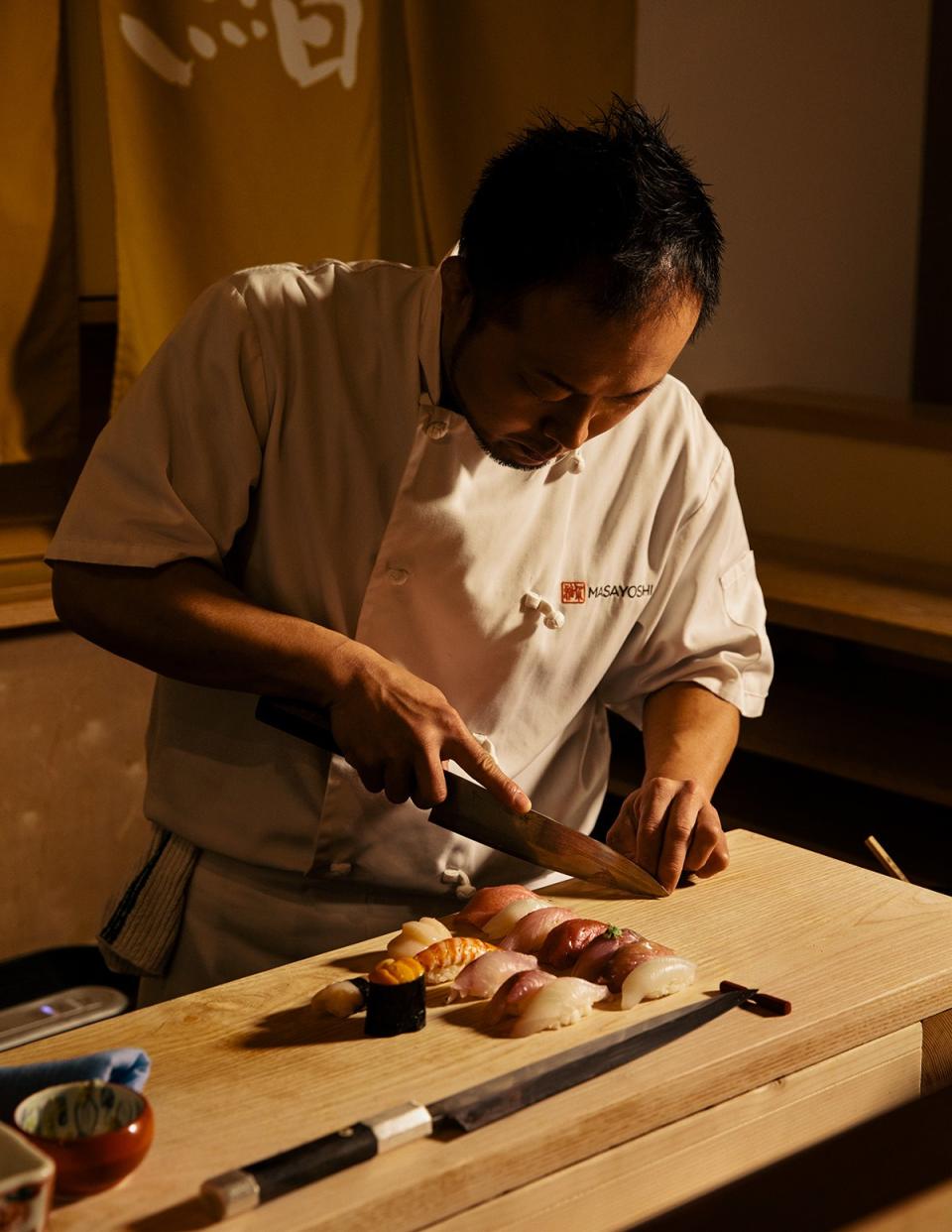 <cite class="credit"><em>Photo by Grant Harder</em> | Chef Masayoshi Baba preparing sushi at Masayoshi</cite>