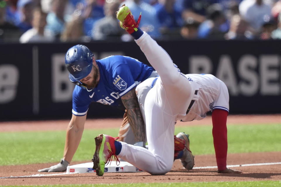 Kansas City Royals center fielder Kyle Isbel (28) slides into third base with a triple past the tag of Toronto Blue Jays third baseman Santiago Espinal during the sixth inning of a baseball game in Toronto on Sunday, Sept. 10, 2023. (Nathan Denette/The Canadian Press via AP)