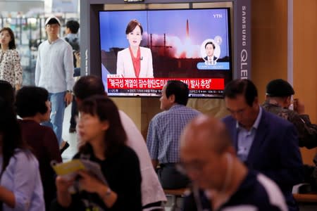 People watch a TV screening of a file footage in Seoul following North Korea's firing of missile believed to be launched from a submarine