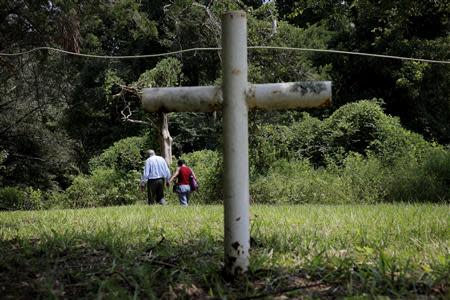 John Due, 78, of Atlanta, Georgia, leaves with his daughter Tananarive Due, 47 (R), after a short memorial ceremony at the Boot Hill cemetery at the now closed Arthur G. Dozier School for Boys in Marianna, Florida, August 31, 2013. REUTERS/Edmund D Fountain/Pool