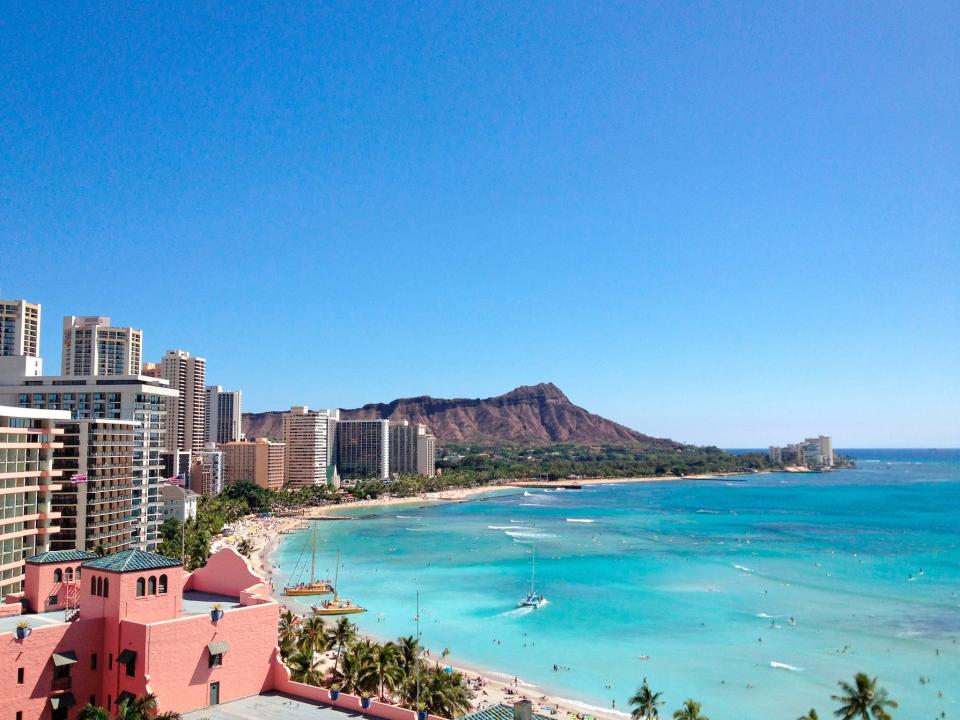 A beach lined with buildings and mountains.