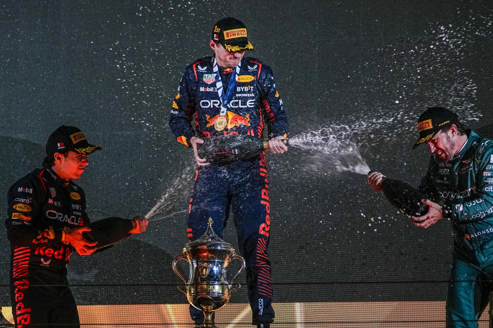 First placed Red Bull driver Max Verstappen of the Netherlands, center, second placed Red Bull driver Sergio Perez of Mexico, left, and third placed Aston Martin driver Fernando Alonso of Spain , right, celebrate on the podium after the Formula One Bahrain Grand Prix at Sakhir circuit, Sunday, March 5, 2023. (AP Photo/Ariel Schalit)