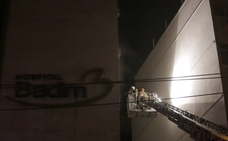 Firefighters work after a fire hit the Badim Hospital in Rio de Janeiro