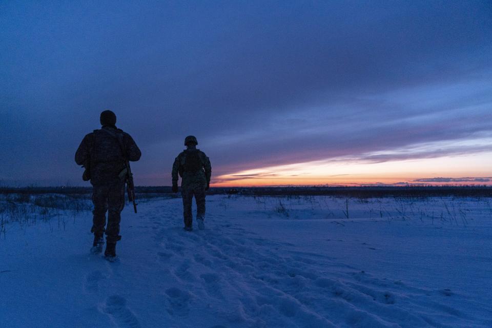 Ukrainian servicemen patrol an area after sunset near their position at the frontline near Vodiane, about 750 kilometers (468 miles) south-east of Kyiv, eastern Ukraine, Saturday, March 5, 2021. The country designated 14,000 doses of its first vaccine shipment for the military, especially those fighting Russia-backed separatists in the east. (AP Photo/Evgeniy Maloletka)