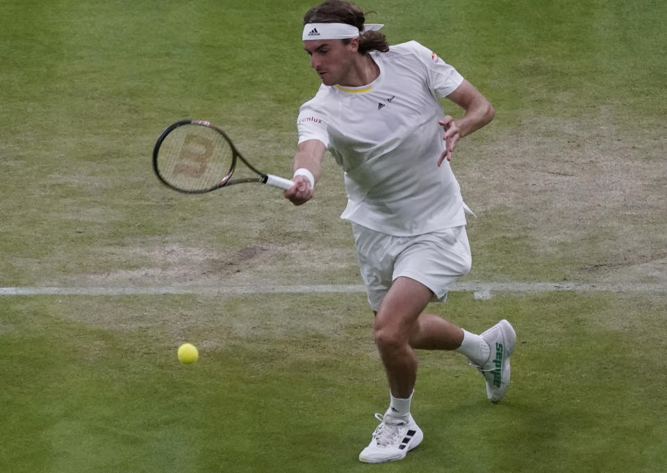 Greece's Stefanos Tsitsipas returns to Australia's Nick Kyrgios during their third round men's singles match on day six of the Wimbledon tennis championships in London, Saturday, July 2, 2022. (AP Photo/Alberto Pezzali)