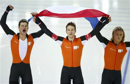 The team from the Netherlands, (L-R) Sven Kramer, Jan Blokhuijsen and Koen Verweij celebrate after competing in the men's speed skating team pursuit Gold-medal final during the 2014 Sochi Winter Olympics, February 22, 2014. REUTERS/Marko Djurica