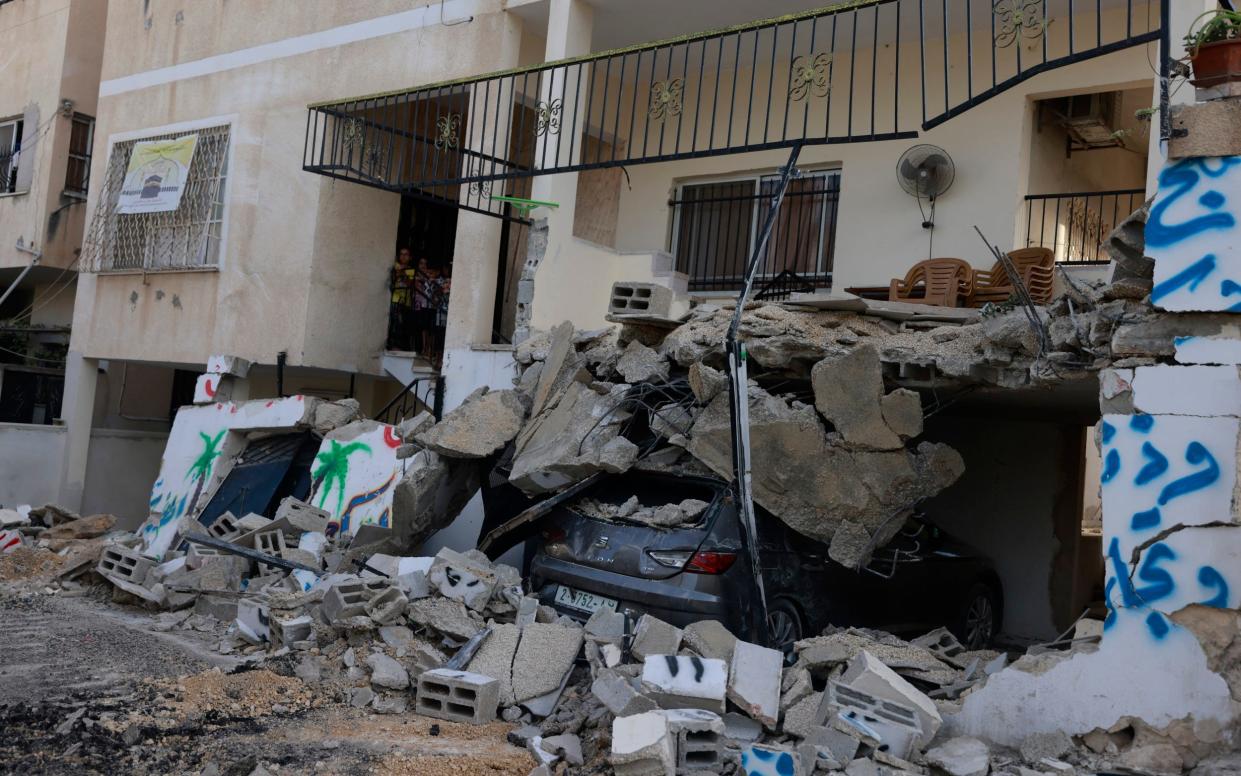 A car lies buried under a residential building  destroyed by an Israeli raid in the Nur Shams camp near the city of Tulkarem