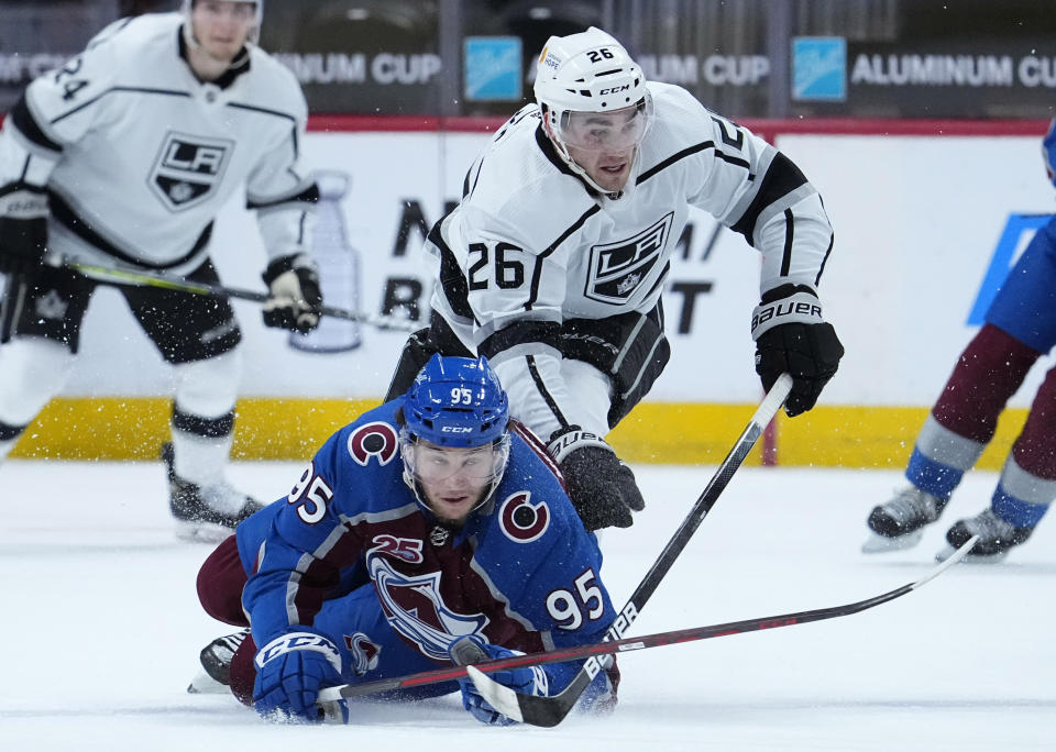 Los Angeles Kings defenseman Sean Walker (26) knocks down Colorado Avalanche left wing Andre Burakovsky (95) during the first period of an NHL hockey game Thursday, May, 13, 2021, in Denver. (AP Photo/Jack Dempsey)