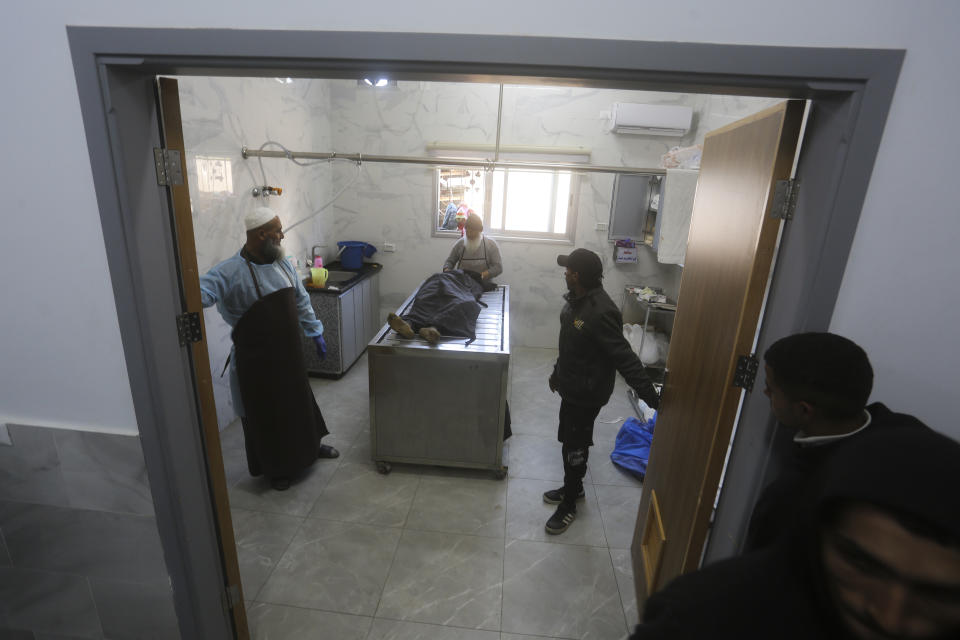 The body of a Palestinian killed in the Israeli bombardment of the Gaza Strip is prepared for burial in a morgue of the European Gaza Hospital in Rafah, Saturday, Jan. 6, 2024. (AP Photo/Hatem Ali)