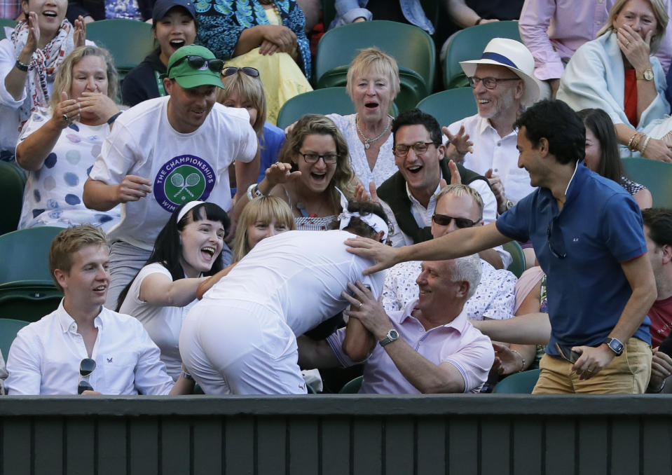 Rafael Nadal of Spain crashes into the crowd during the men’s quarterfinal match against Juan Martin Del Potro of Argentina at the Wimbledon Tennis Championships in London, Wednesday July 11, 2018. (AP Photo/Kirsty Wigglesworth)