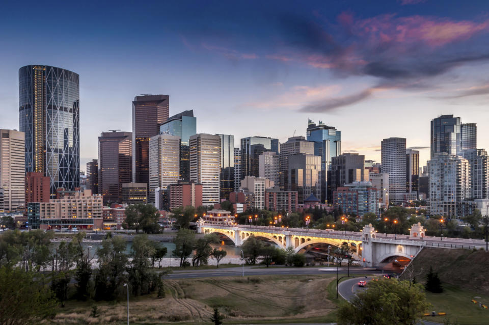 The Calgary skyline is shown at night with Bow River and Centre Street Bridge. Calgary's livability score was 96.6.