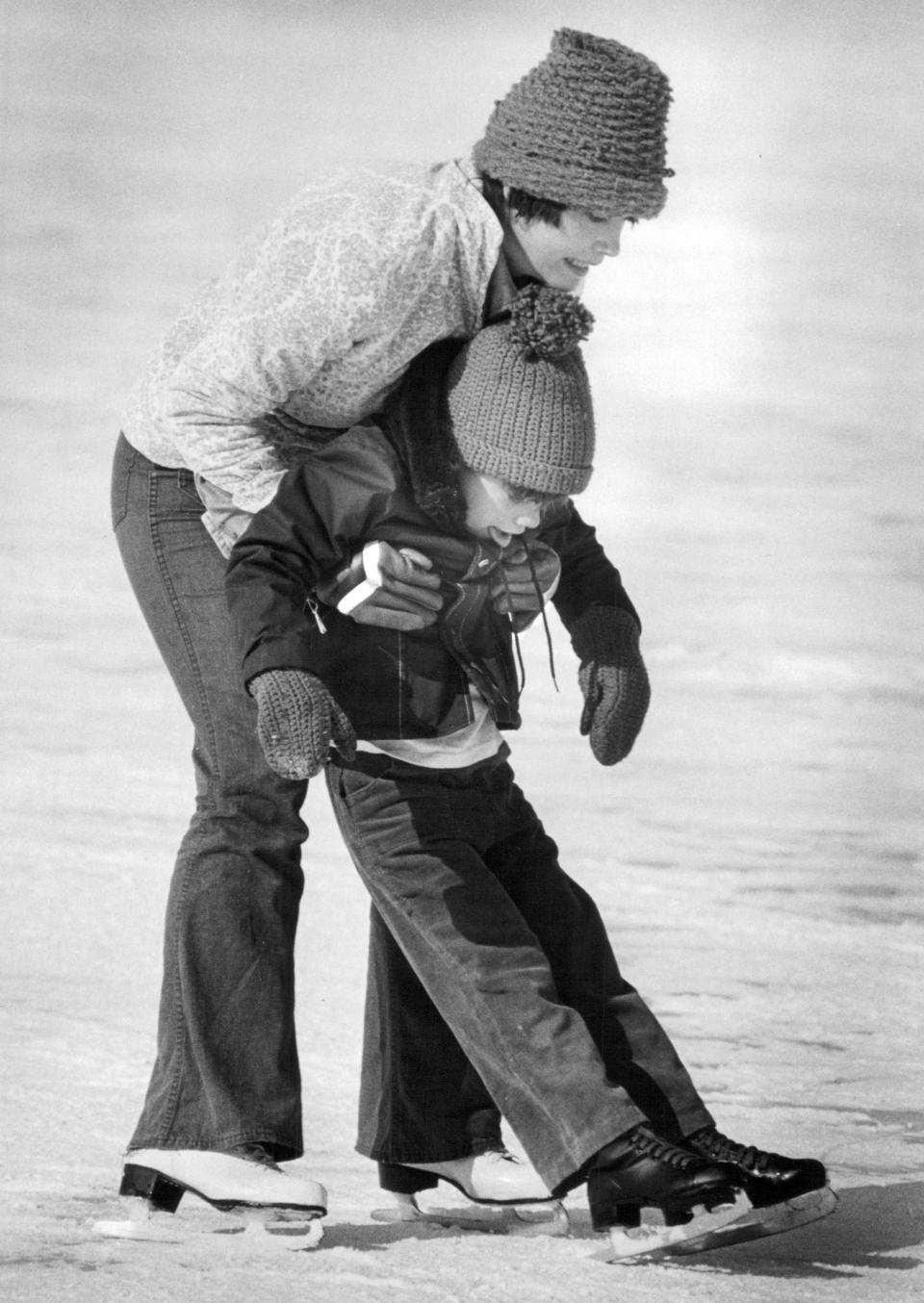 Nancy Curtis helps Trent Culbertson, 5, stand up as he learns to skate for the first time in 1979