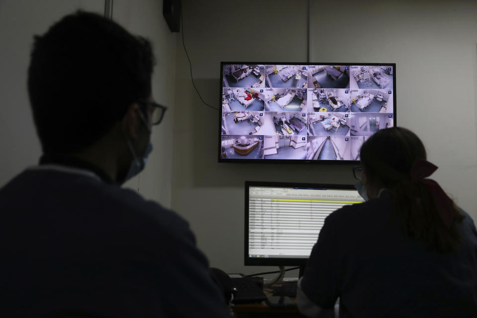 Medical staff monitor COVID-19 patients on CCTV screens at the intensive care unit of the Rafik Hariri University Hospital in Beirut, Lebanon, Friday, Jan. 22, 2021. Hospitals in Lebanon are reaching full capacity amid a dramatic surge in coronavirus cases across the crisis-hit Mediterranean nation even amid strict lockdown. (AP Photo/Bilal Hussein)