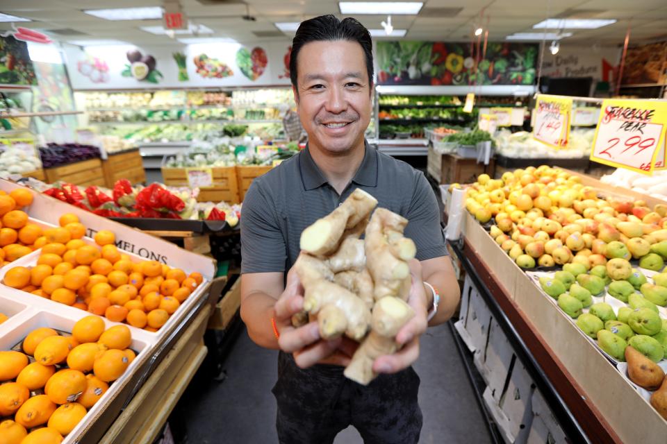 President of Kam Man Market in East Hanover, William Woo, poses with ginger in the produce section of his store. Monday, July 26, 2021