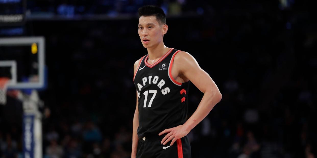 Jeremy Lin stands with a hand on his hip and looks on during a Raptors game in 2019.