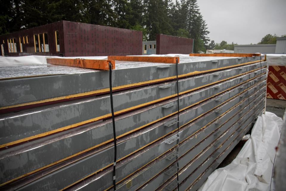 Prefabricated building panels sit next to the permanent modular school addition underway at David Cameron Elementary in Colwood, B.C. The expansion, which will allow the busy school to take on 190 more students, is slated for completion by September 2024. 