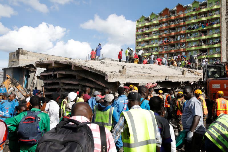 People watch as rescue teams search the scene where a building collapsed in Nairobi
