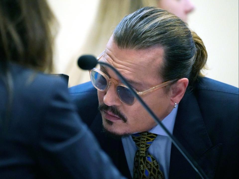 Actor Johnny Depp talks to his attorney, in the courtroom at the Fairfax County Circuit Courthouse in Fairfax, Virginia, USA, 23 May 2022 (EPA)