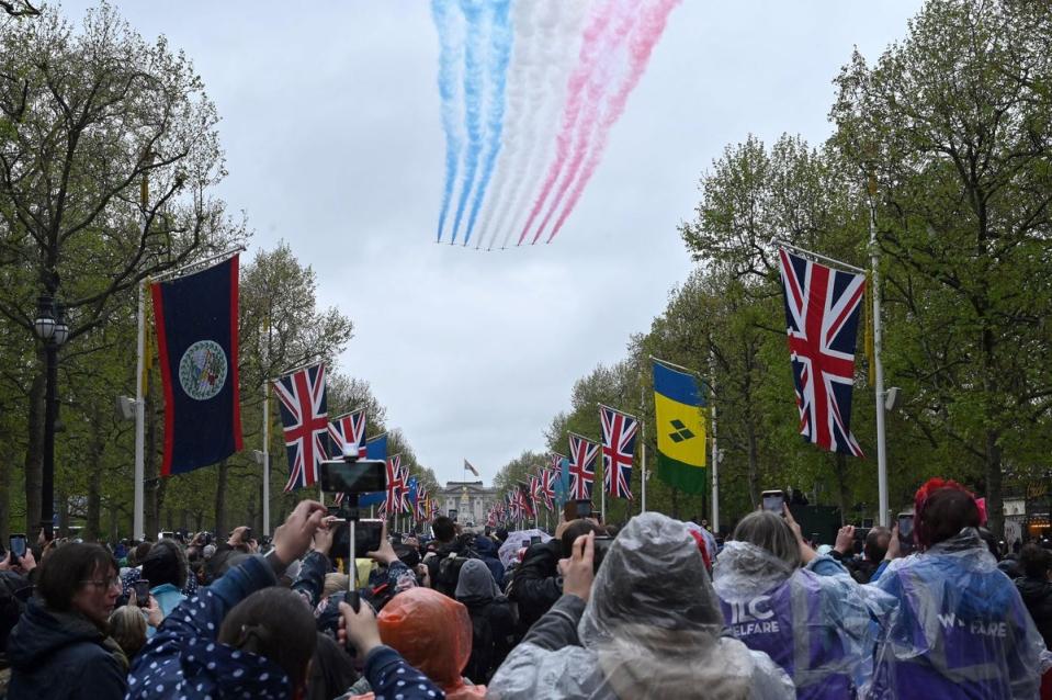 Crowds watch the Royal Air Force Red Arrows perform a flypast over The Mall following the coronation of King Charles on May 6, 2023 (Getty Images)