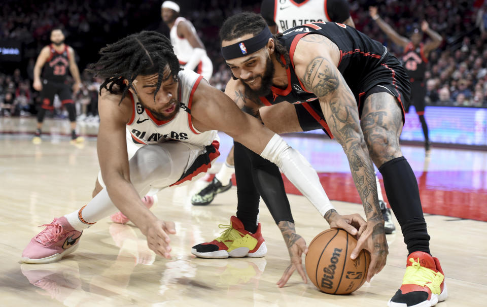 Portland Trail Blazers forward Trendon Watford, left, and Toronto Raptors guard Gary Trent Jr. go after the ball during the first half of an NBA basketball game in Portland, Ore., Saturday, Jan. 28, 2023. (AP Photo/Steve Dykes)