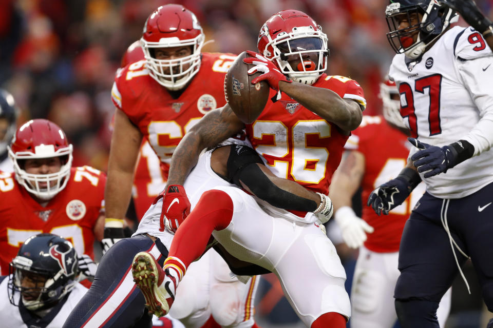 Kansas City Chiefs running back Damien Williams (26) scores a touchdown past Houston Texans safety Justin Reid (20) during the second half of an NFL divisional playoff football game, in Kansas City, Mo., Sunday, Jan. 12, 2020. (AP Photo/Jeff Roberson)
