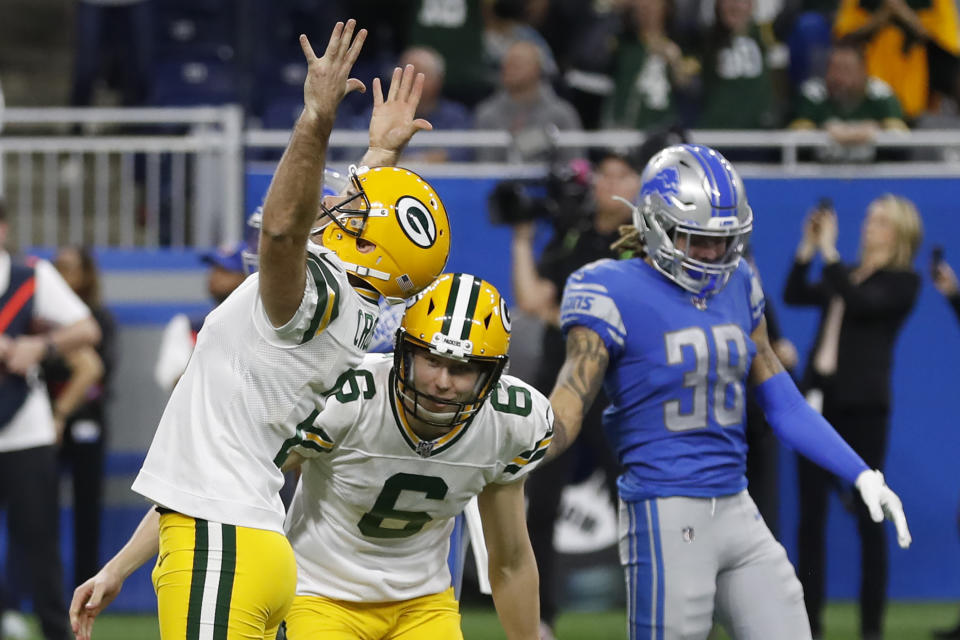 Green Bay Packers kicker Mason Crosby raises his arms after making the winning field goal during the second half of an NFL football game against the Detroit Lions, Sunday, Dec. 29, 2019, in Detroit. Lions defensive back Mike Ford (38) looks on. (AP Photo/Carlos Osorio)