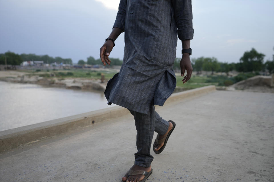 An atheist walks past a bridge looking over the river Yobe in Gashua Nigeria Tuesday, July 11, 2023. Nonbelievers in Nigeria said they perennially have been treated as second-class citizens in the deeply religious country whose 210 million population is almost evenly divided between Christians dominant in the south and Muslims who are the majority in the north. Some nonbelievers say threats and attacks have worsened in the north since the leader of the Humanist Association of Nigeria, Mubarak Bala, was arrested and later jailed for blasphemy. (AP Photo/Sunday Alamba)