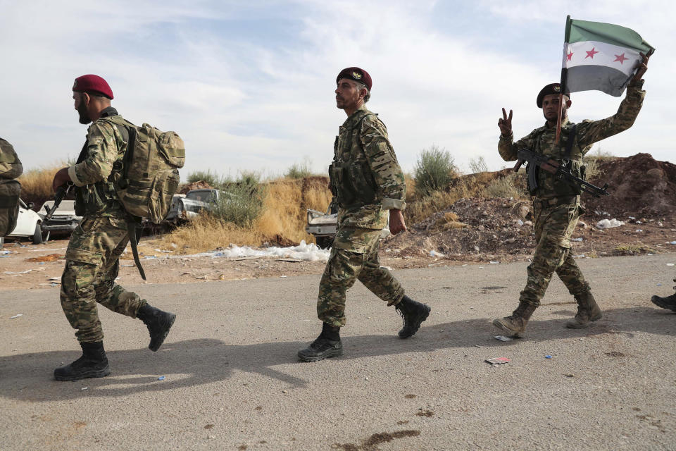 Syrian Kurdish fighters of Turkey-backed Free Syrian Army enter Turkey from Syria to join fighting alongside Turkish forces against US-backed Kurds, in Syria, Friday, Oct. 11, 2019. Turkish forces pushed deeper into northeastern Syria on Friday, the third day of Ankara's cross-border offensive against Syrian Kurdish fighters that has set off another mass displacement of civilians and met with widespread criticism from the international community.(Ugur Can/DHA via AP)