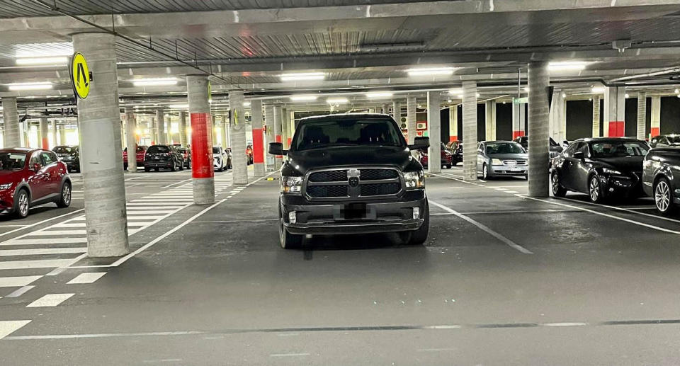 The black SUV parked in a traffic lane in a Melbourne car park.