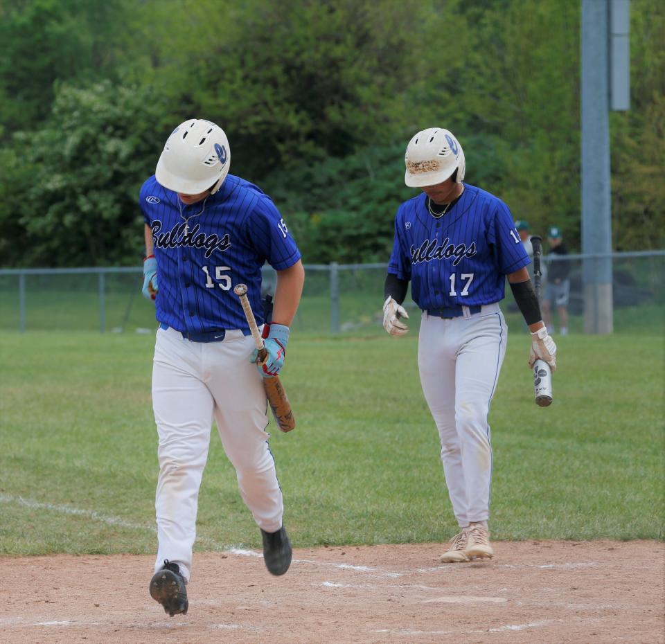 Centerville junior Gavin Robinson (left) jogs back to the dugout while senior Wade Lambright (right) steps into the batter's box during a Wayne County Tournament game against Centerville May 13, 2023.