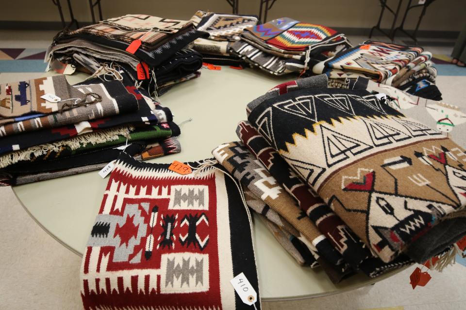 Part of a collection of 425 Navajo weavings from the estate of Bob Culpepper is arranged on a table at the Farmington Museum at Gateway Park on Aug. 6.