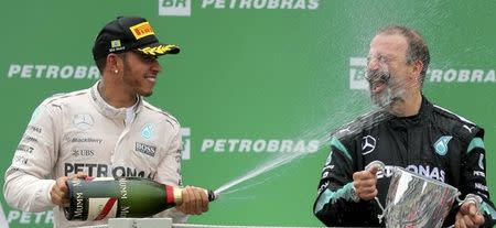 Mercedes Formula One driver Lewis Hamilton (L) of Britain celebrates with Mercedes' race team composite technician James Waddell after the Brazilian F1 Grand Prix in Sao Paulo, Brazil, November 15, 2015. REUTERS/Paulo Whitaker